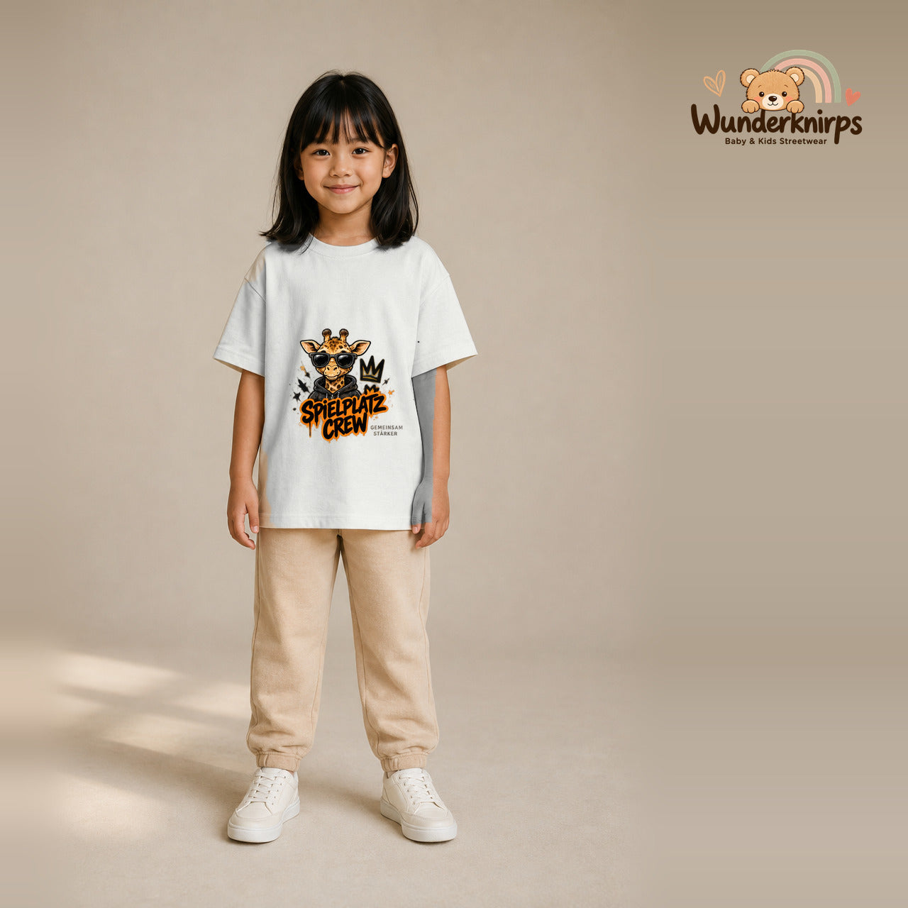 T-Shirt für Mädchen in Weiß mit Motiv „Spielplatz Crew“, getragen von einem Kind – Wunderknirps.
