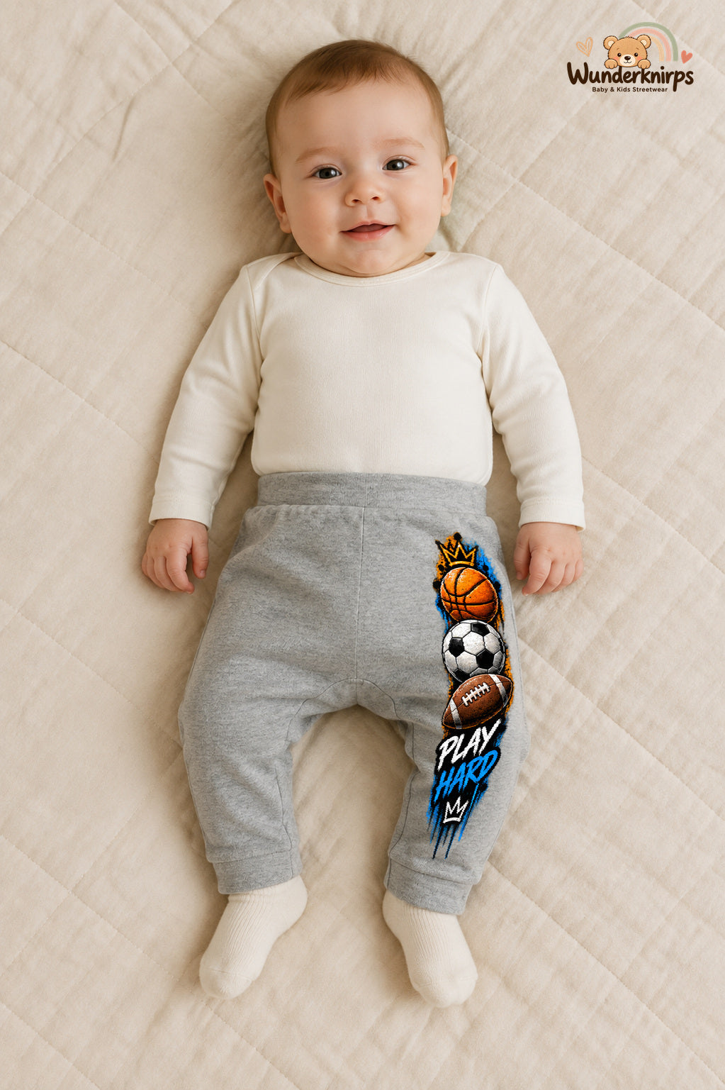 Play hard – Babyhose mit dem Motiv Sportbälle – für Jungen: Grau meliert mit Sportbälle-Druck am Hosenbein – Wunderknirps.