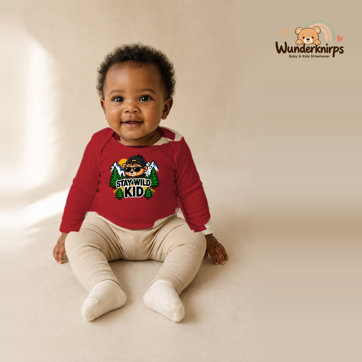 Babybody für Mädchen in Rot mit Motiv „Stay Wild Kid“, getragen von einem Kind – Wunderknirps.