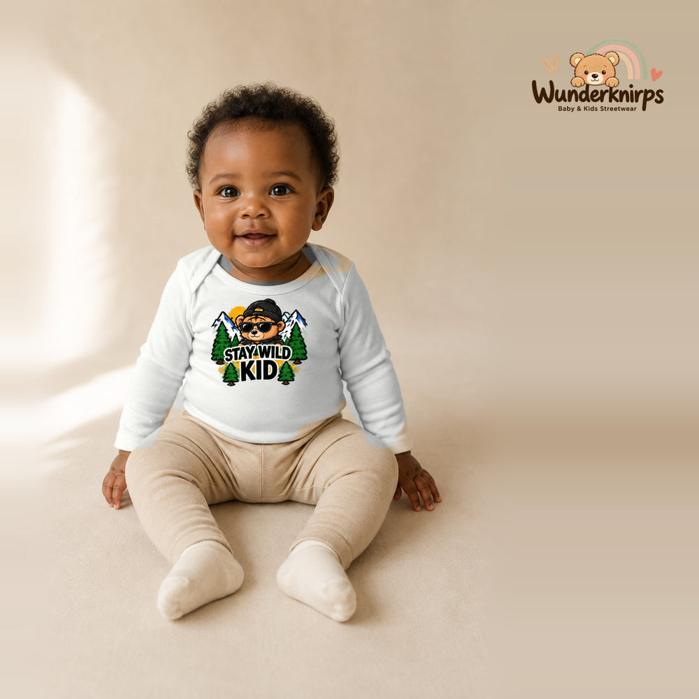Babybody für Mädchen in Weiß mit Motiv „Stay Wild Kid“, getragen von einem Kind – Wunderknirps.