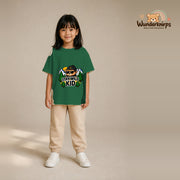 T-Shirt für Mädchen in Grün mit Motiv „Stay Wild Kid“, getragen von einem Kind – Wunderknirps.