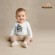 Babybody für Jungen in Weiß mit Motiv „Stay Wild Little One“, getragen von einem Kind – Wunderknirps.