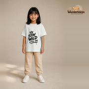 T-Shirt für Mädchen in Weiß mit Motiv „Stay Wild Little One“, getragen von einem Kind – Wunderknirps.