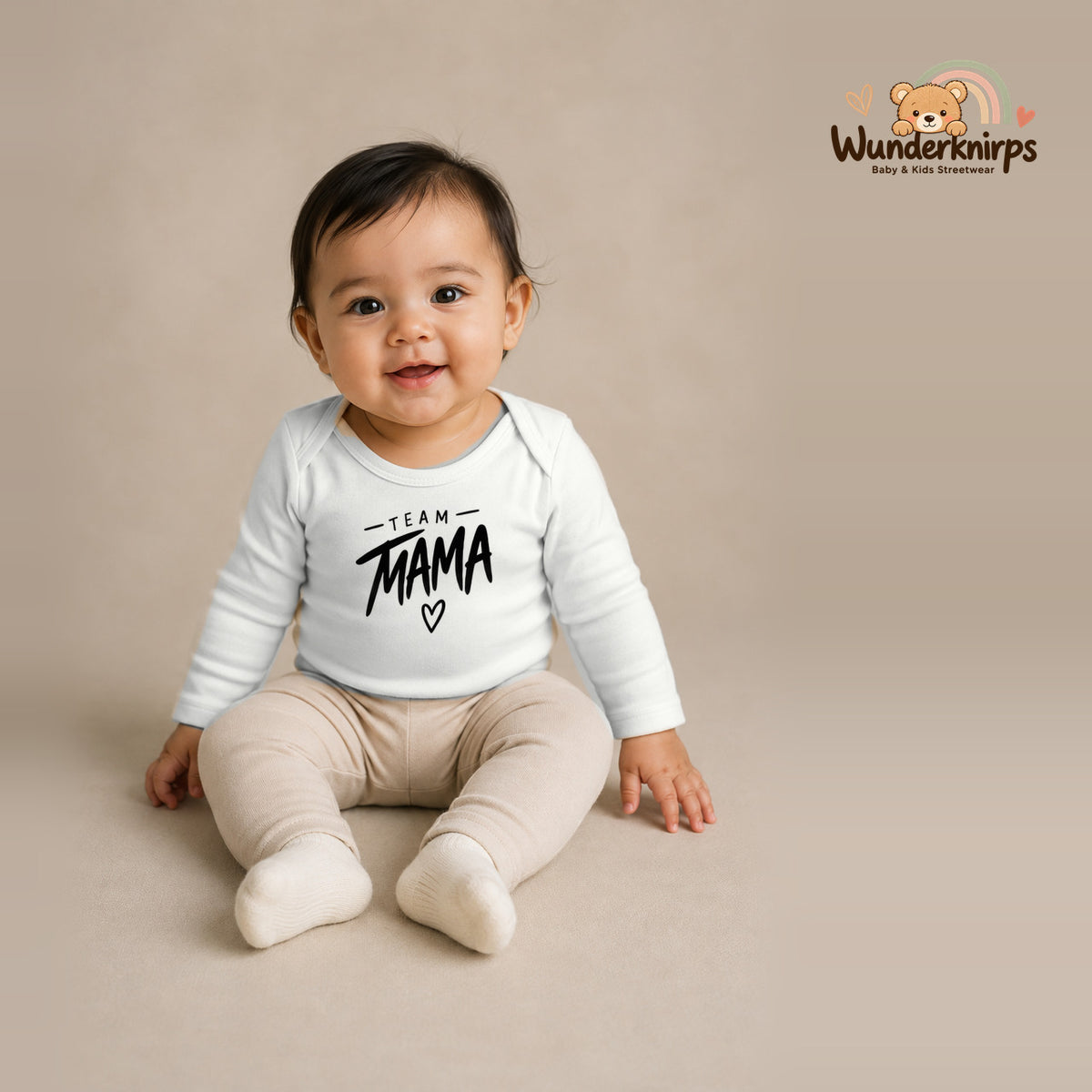 Babybody für Mädchen in Weiß mit Motiv „Team Mama“, getragen von einem Kind – Wunderknirps.