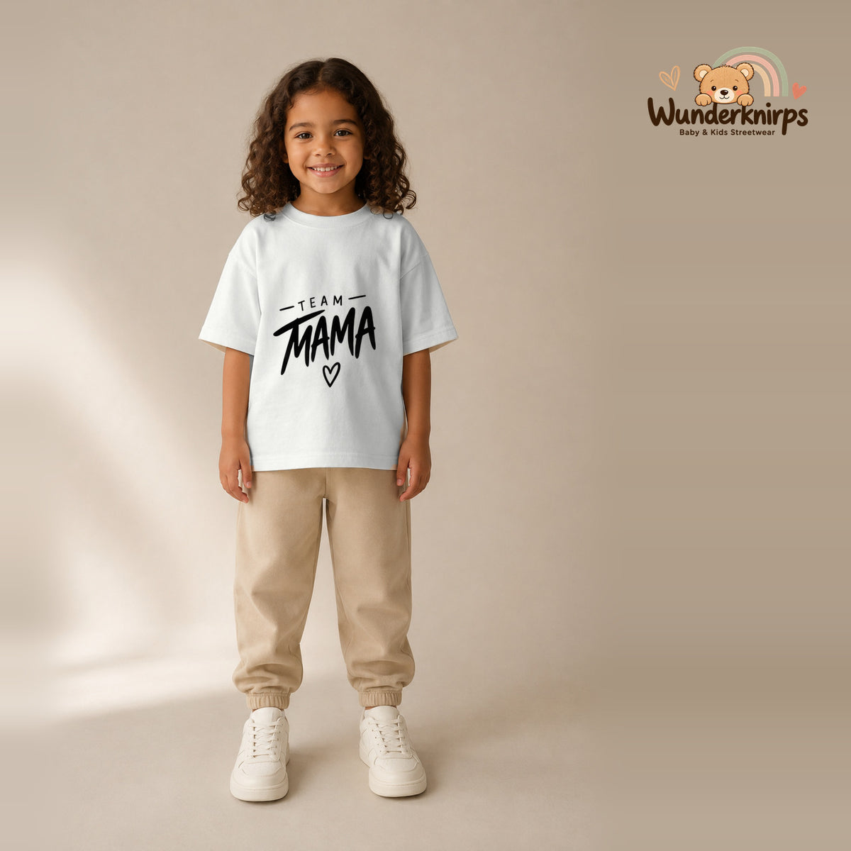 T-Shirt für Mädchen in Weiß mit Motiv „Team Mama“, getragen von einem Kind – Wunderknirps.