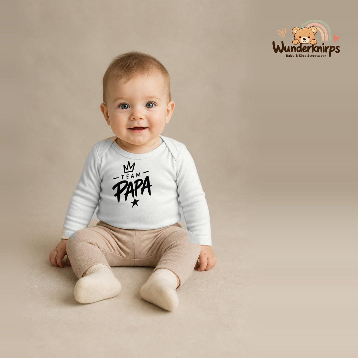 Babybody für Jungen in Weiß mit Motiv „Team Papa“, getragen von einem Kind – Wunderknirps.