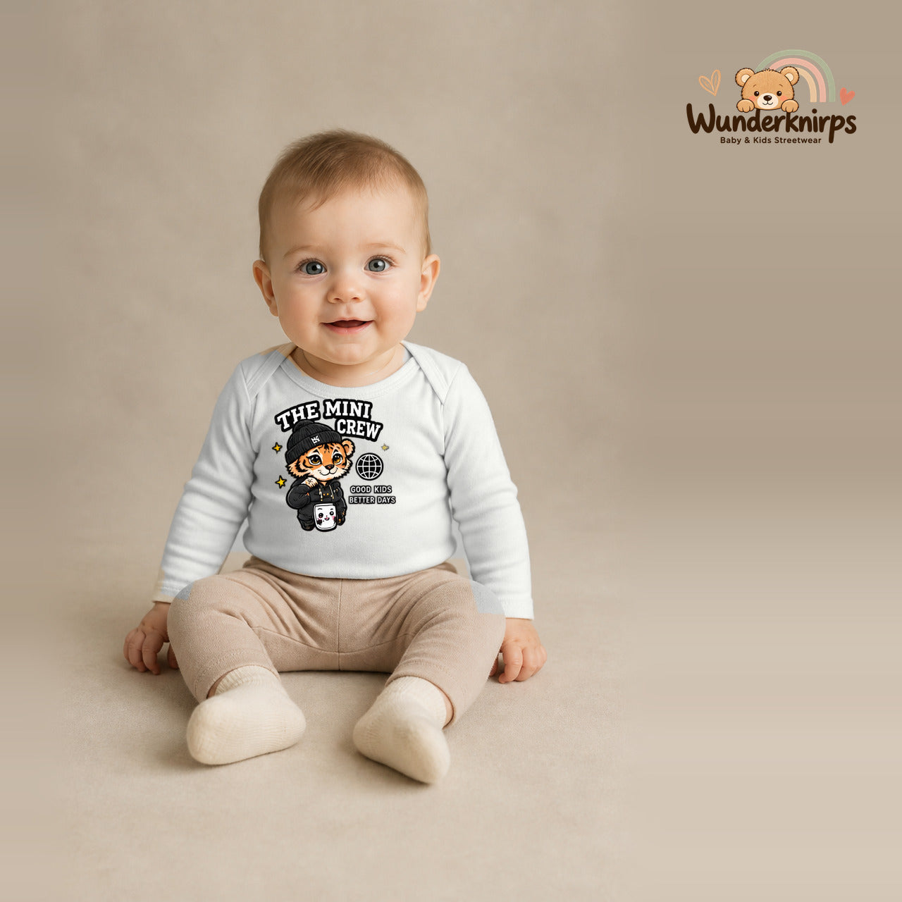 Babybody für Jungen in Weiß mit Motiv „The Mini Crew“, getragen von einem Kind – Wunderknirps.