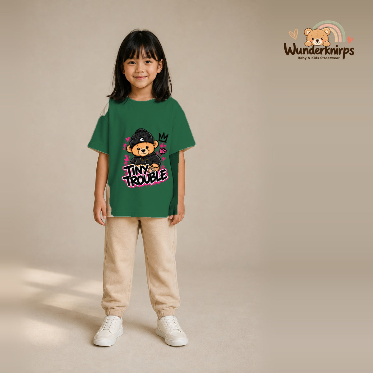 T-Shirt für Mädchen in Grün mit Motiv „Tiny Trouble“, getragen von einem Kind – Wunderknirps.