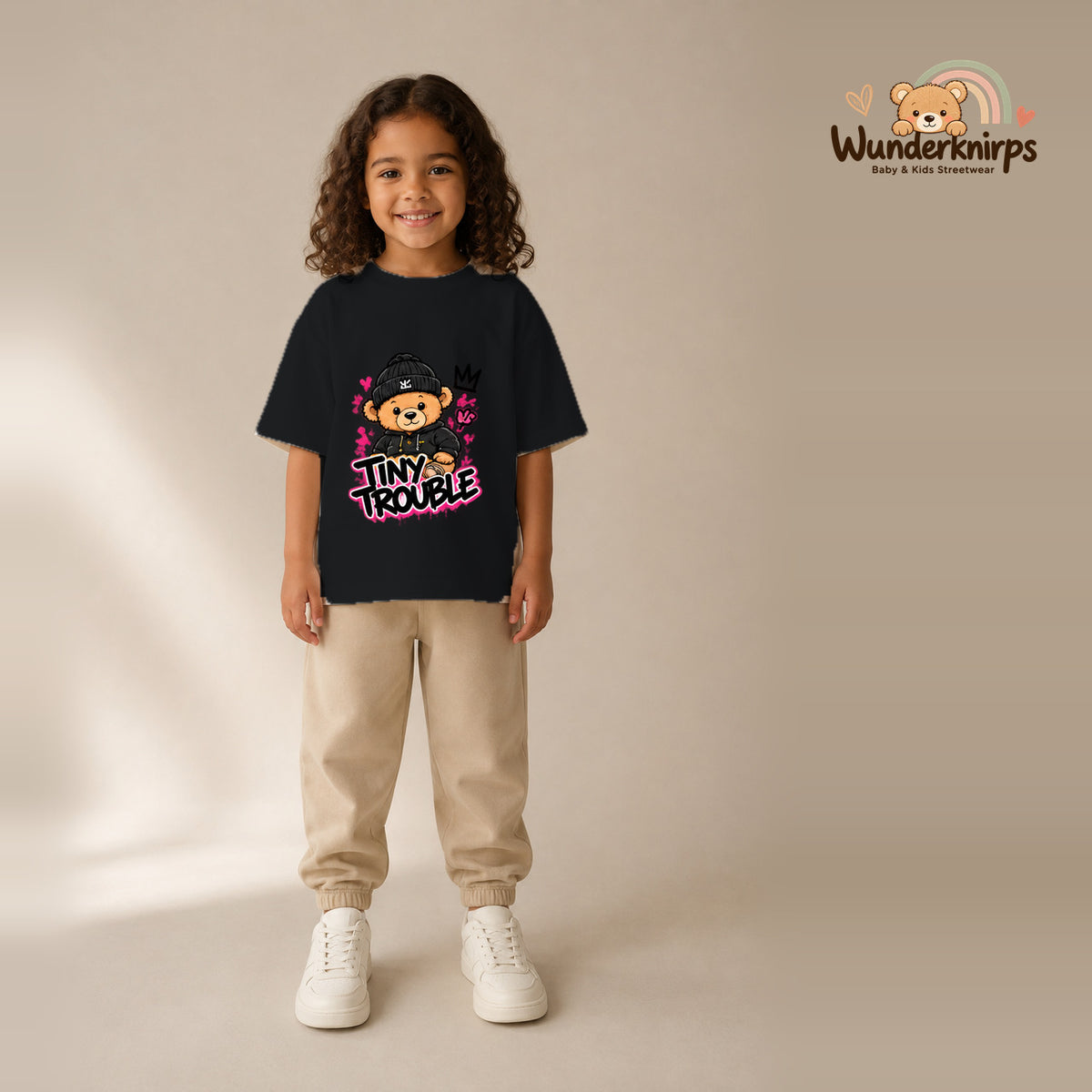 T-Shirt für Mädchen in Schwarz mit Motiv „Tiny Trouble“, getragen von einem Kind – Wunderknirps.