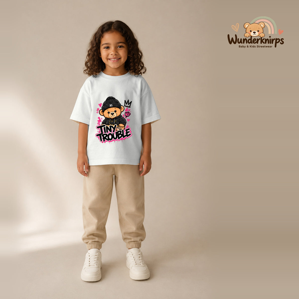 T-Shirt für Mädchen in Weiß mit Motiv „Tiny Trouble“, getragen von einem Kind – Wunderknirps.