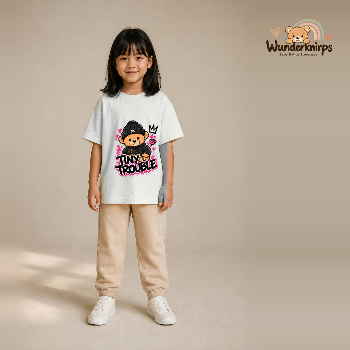 T-Shirt für Mädchen in Weiß mit Motiv „Tiny Trouble“, getragen von einem Kind – Wunderknirps.