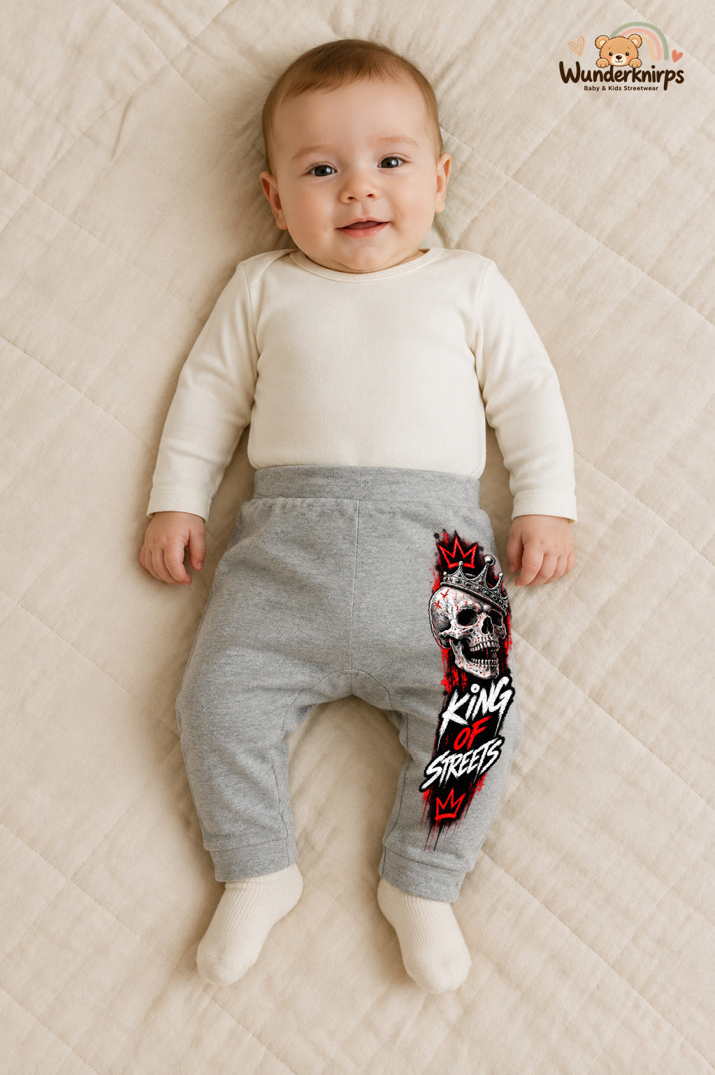 Totenkopf Alltagsheld – King of streets – Babyhose für Jungen: Grau meliert mit Totenkopf-Druck am Hosenbein – Wunderknirps.