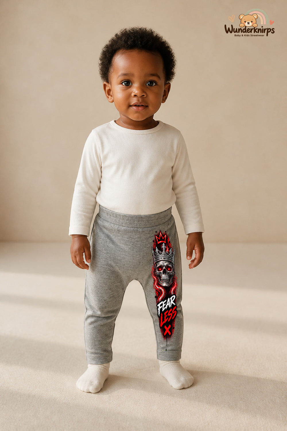 Kleine Weltentdeckerin: Fearless – Babyhose für Mädchen: Grau meliert mit Totenkopf-Druck am Hosenbein – Wunderknirps.