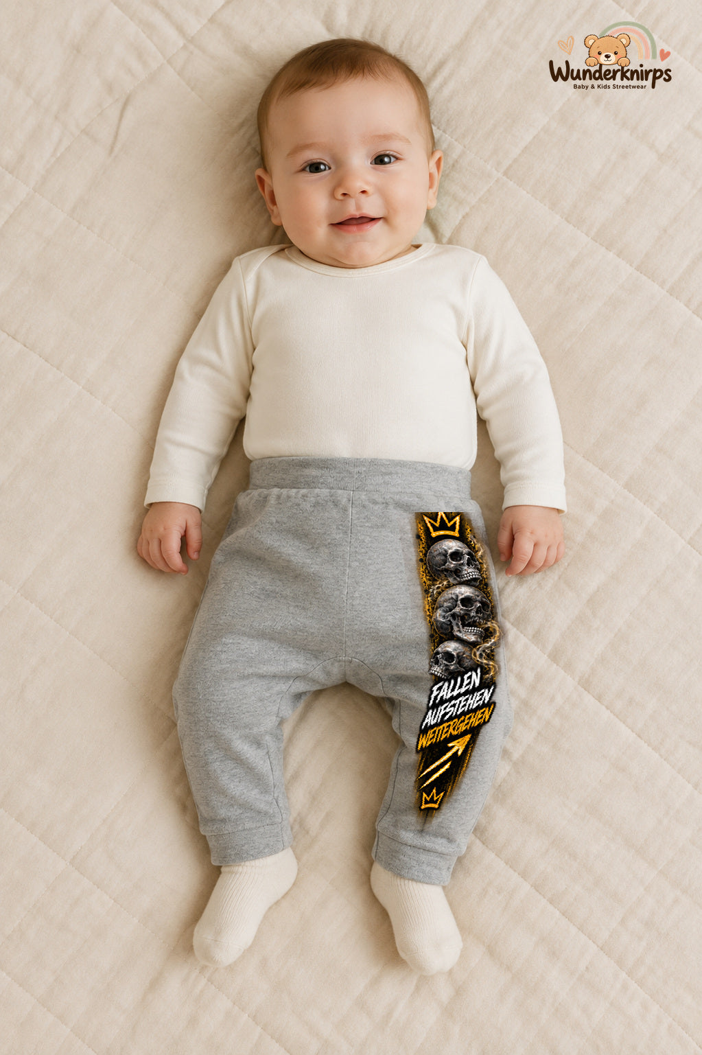 Totenschädel Streetstyle – Fallen aufstehen weitergehen – Babyhose für Jungen: Grau meliert mit Totenschädel-Druck am Hosenbein – Wunderknirps.