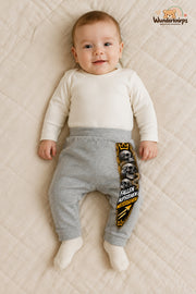 Totenschädel Streetstyle – Fallen aufstehen weitergehen – Babyhose für Jungen: Grau meliert mit Totenschädel-Druck am Hosenbein – Wunderknirps.