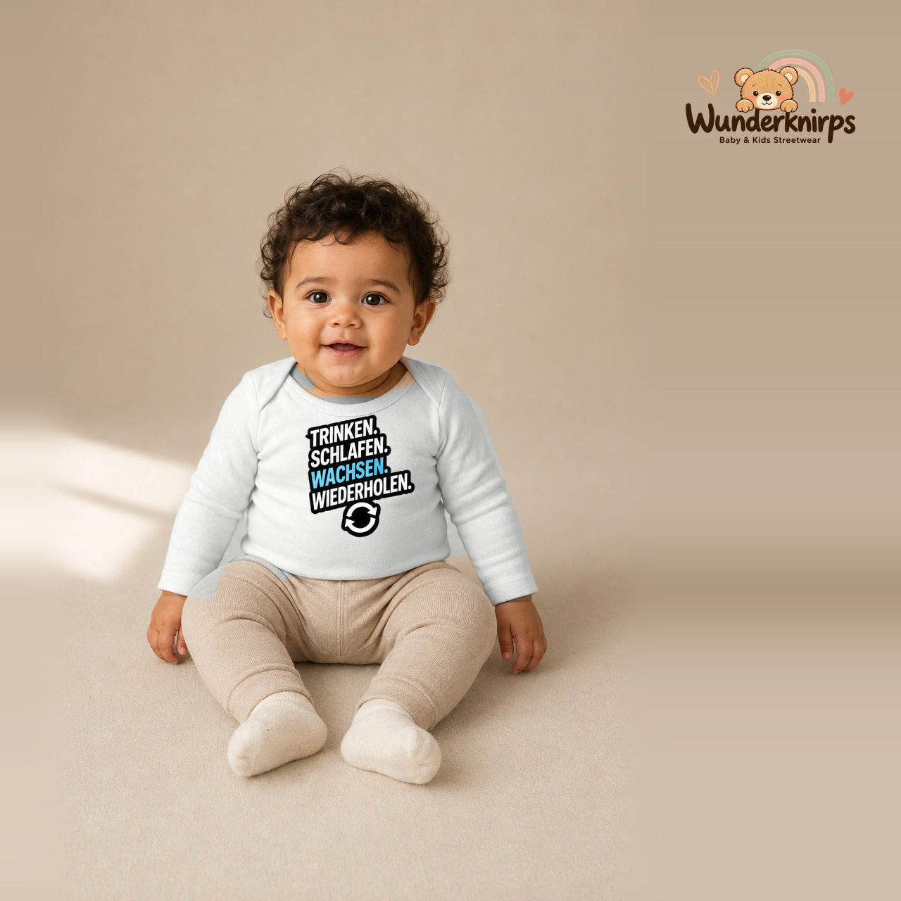 Babybody für Jungen in Weiß mit Motiv „Trinken Schlafen Wachsen“, getragen von einem Kind – Wunderknirps.
