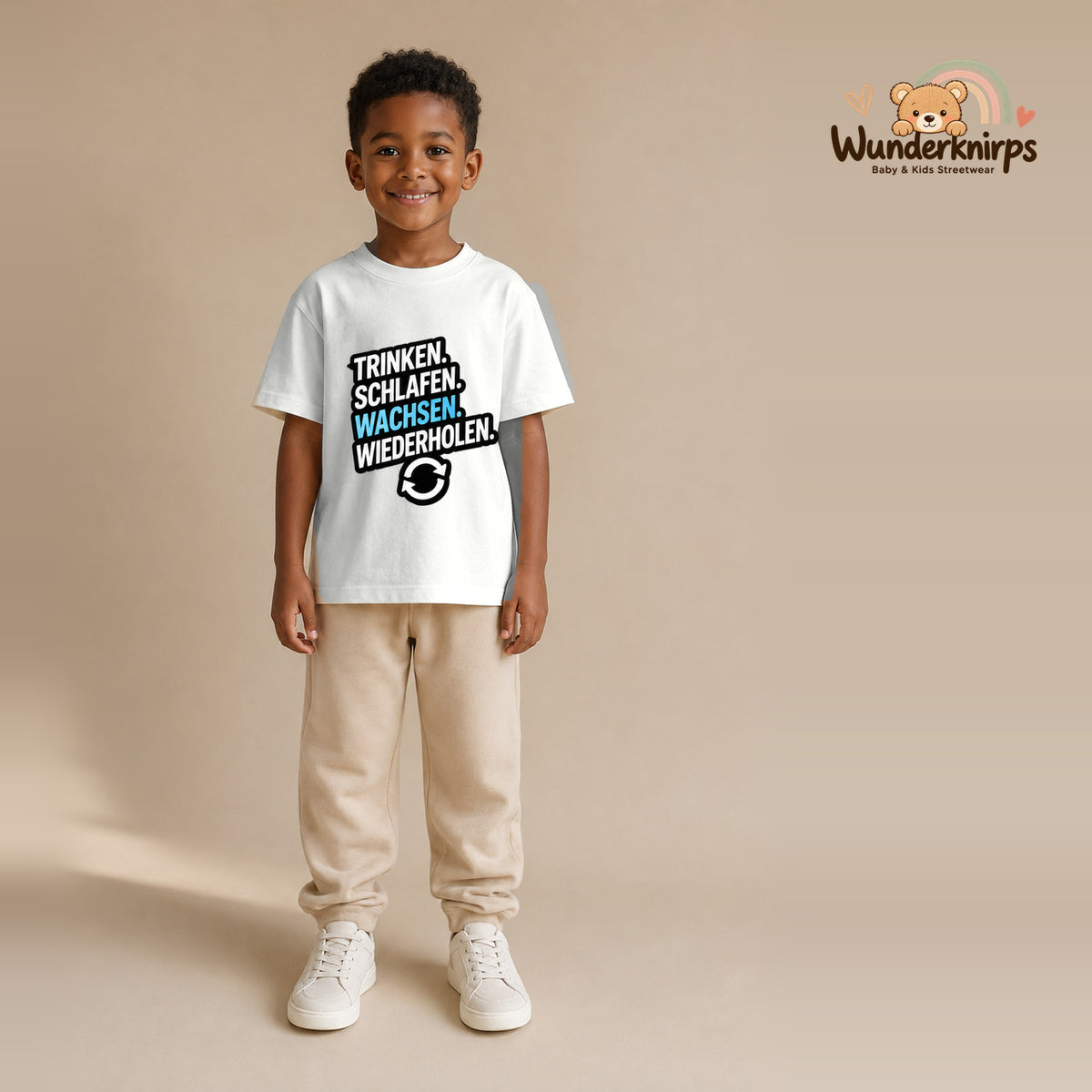 T-Shirt für Jungen in Weiß mit Motiv „Trinken Schlafen Wachsen“, getragen von einem Kind – Wunderknirps.