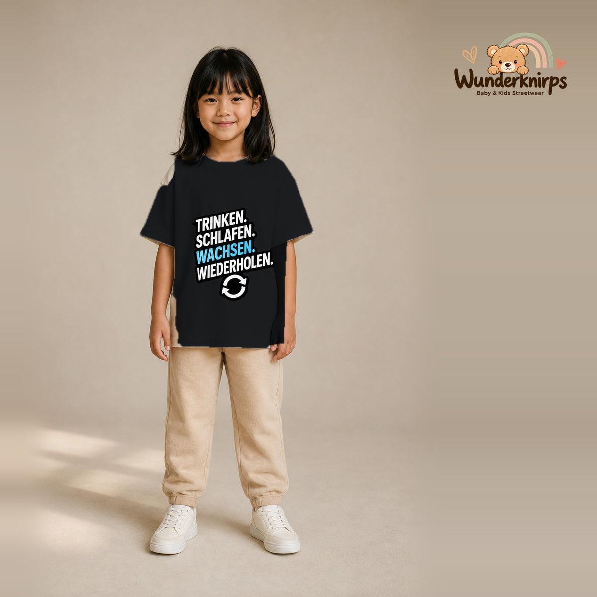 T-Shirt für Mädchen in Schwarz mit Motiv „Trinken Schlafen Wachsen“, getragen von einem Kind – Wunderknirps.