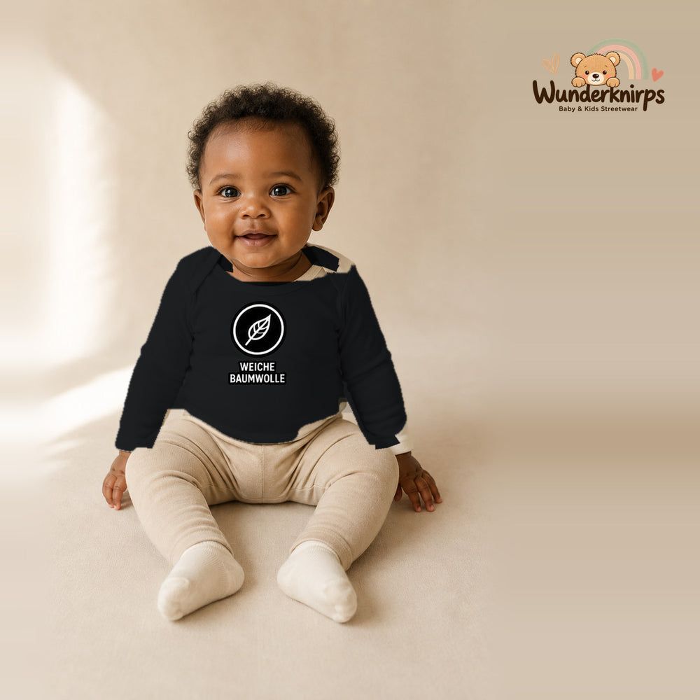 Babybody für Mädchen in Schwarz mit Motiv „Weiche Baumwolle“, getragen von einem Kind – Wunderknirps.