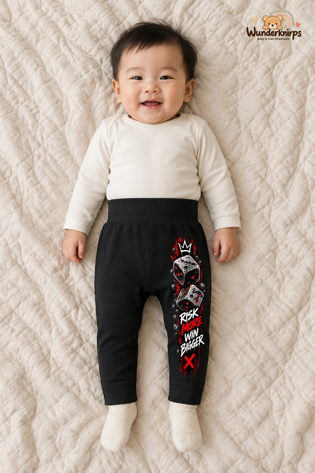 Würfel Alltagsheld – Risk more win bigger – Babyhose für Jungen: Schwarz mit Würfel-Druck am Hosenbein – Wunderknirps.