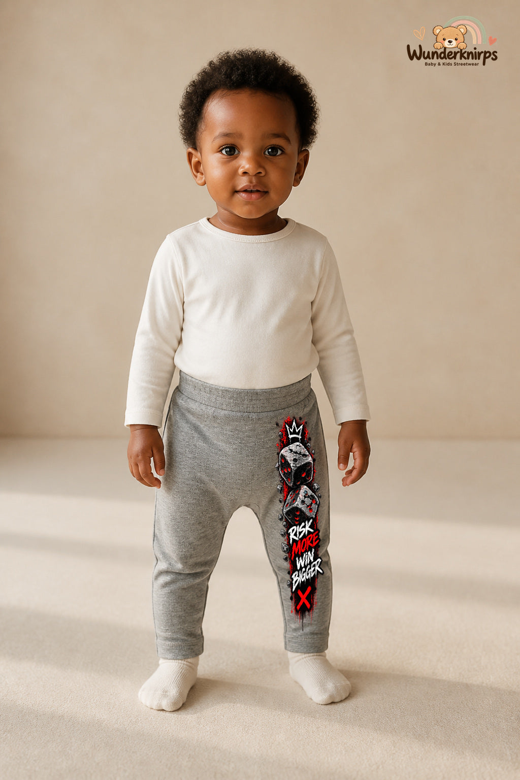 Würfel Traumlook – Risk more win bigger – Babyhose für Mädchen: Grau meliert mit Würfel-Druck am Hosenbein – Wunderknirps.