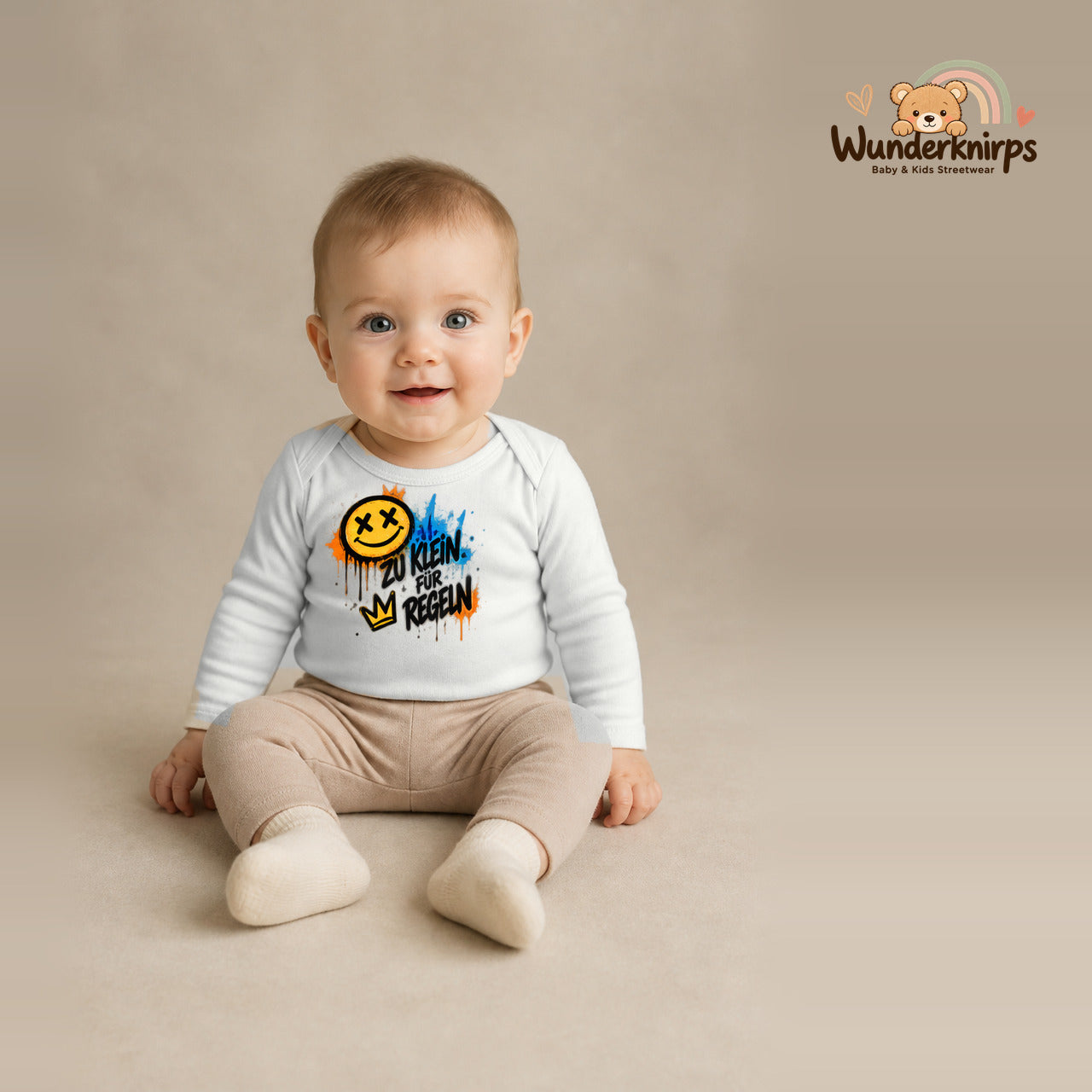 Babybody für Jungen in Weiß mit Motiv „Zu klein für Regeln“, getragen von einem Kind – Wunderknirps.
