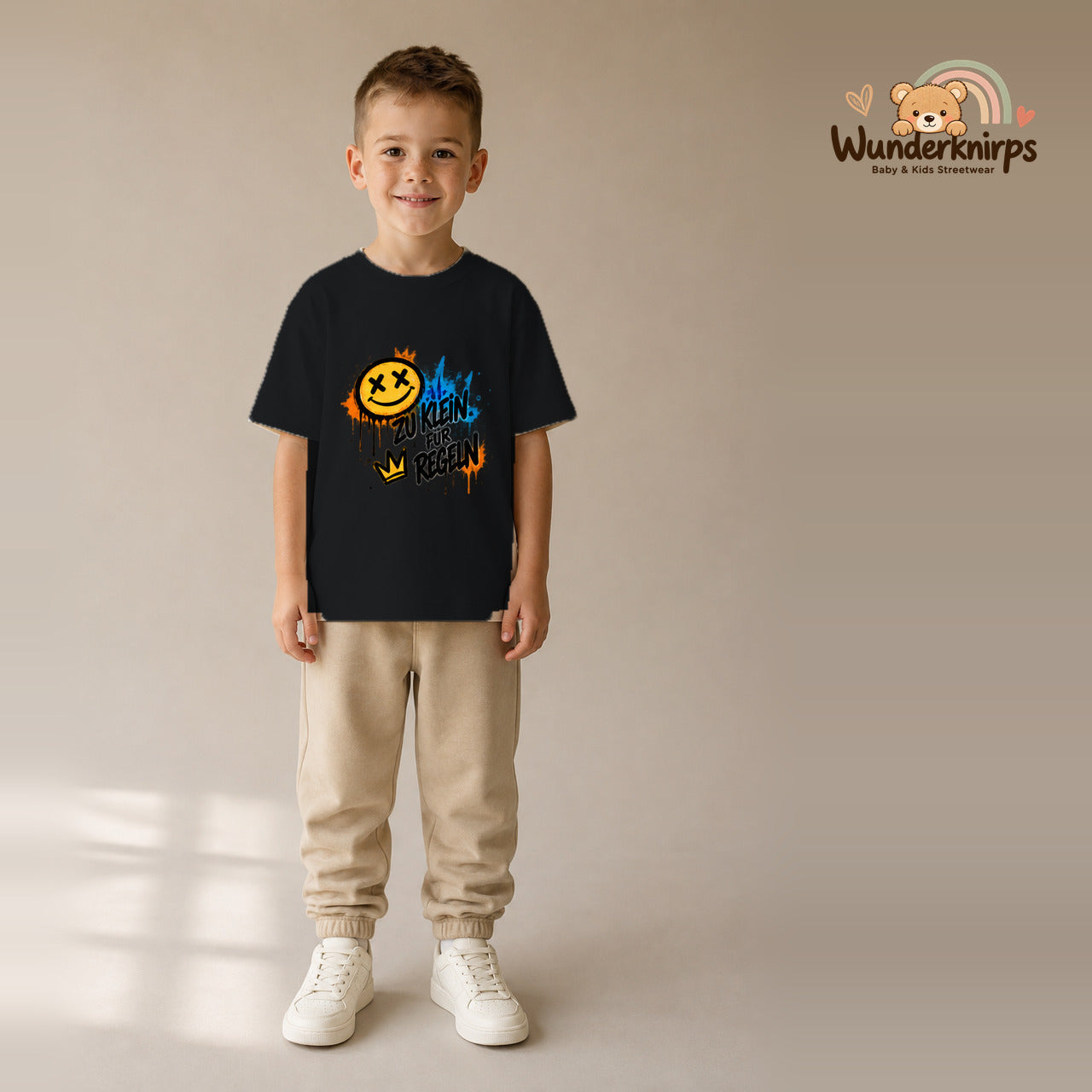 T-Shirt für Jungen in Schwarz mit Motiv „Zu klein für Regeln“, getragen von einem Kind – Wunderknirps.