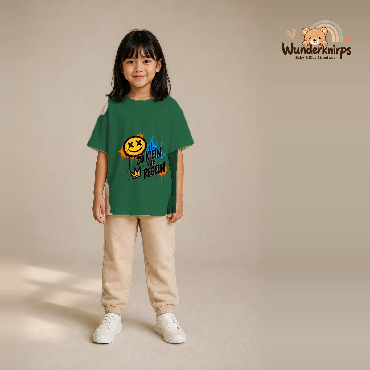 T-Shirt für Mädchen in Grün mit Motiv „Zu klein für Regeln“, getragen von einem Kind – Wunderknirps.