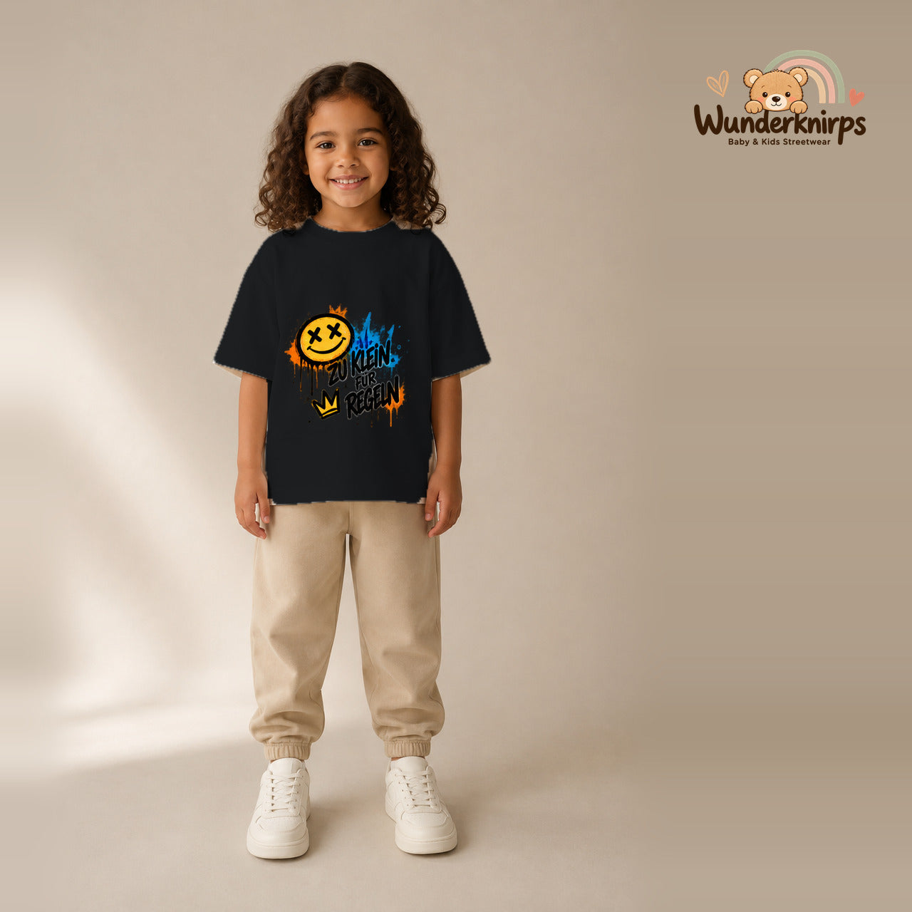 T-Shirt für Mädchen in Schwarz mit Motiv „Zu klein für Regeln“, getragen von einem Kind – Wunderknirps.