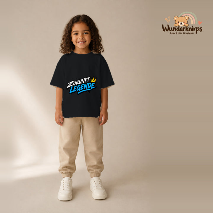 T-Shirt für Mädchen in Schwarz mit Motiv „Zukunft Legende“, getragen von einem Kind – Wunderknirps.